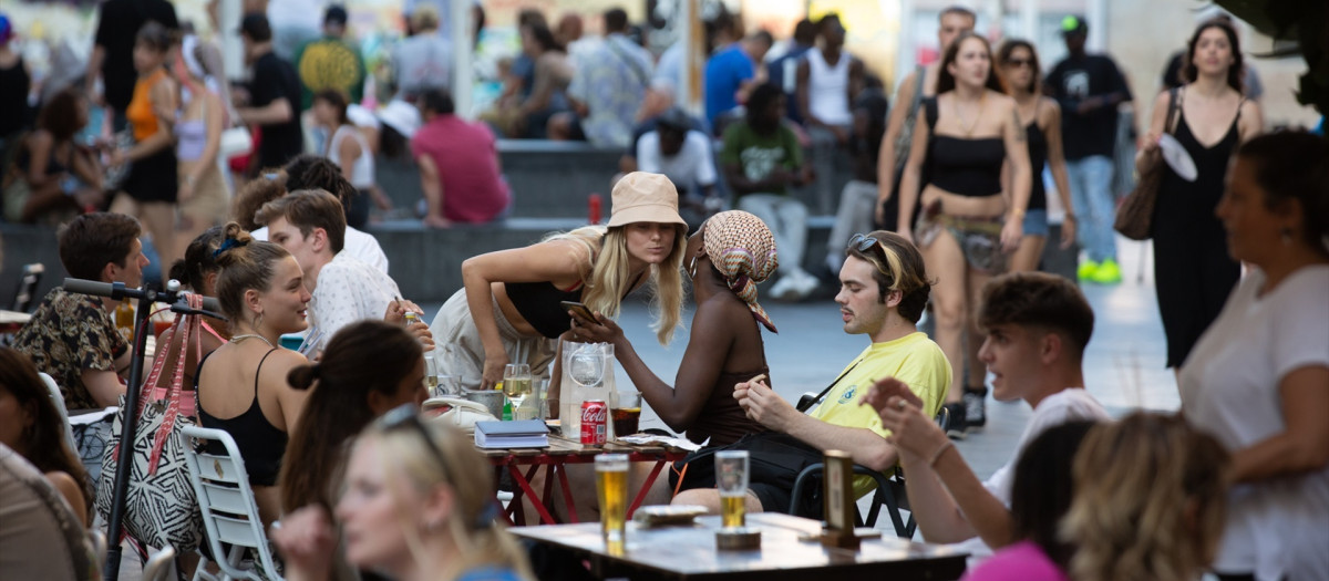 Varias personas sentadas en bares en la plaza dels Àngels del Raval, en Barcelona.