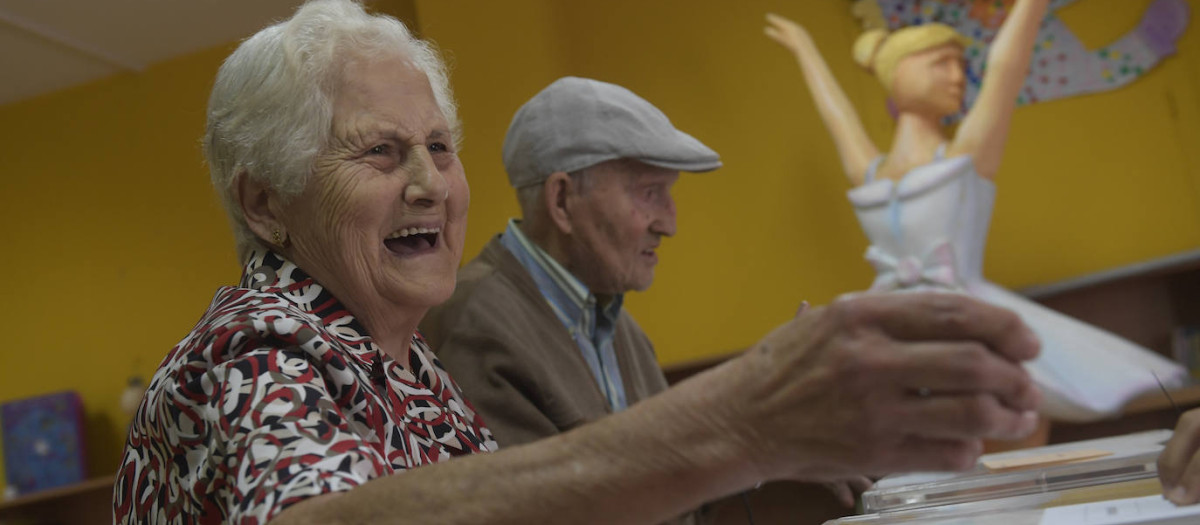 Una pareja de ancianos ejerce su derecho al voto en las elecciones generales en un colegio de Avilés.