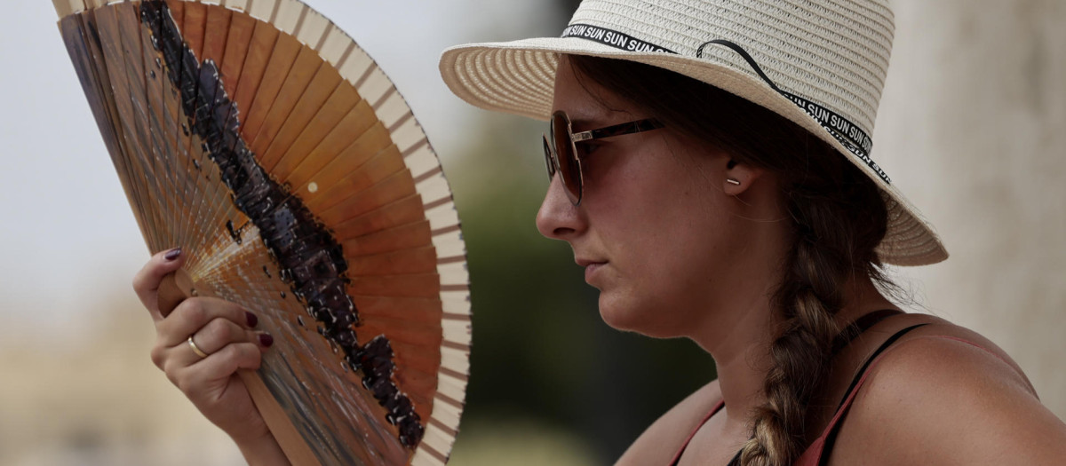 Una joven combate el calor con un abanico