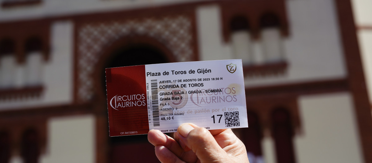 Un aficionado taurino muestra su entrada para uno de los días de la Feria de Begoña ante el coso El Bibio de Gijón. La plaza de toros de El Bibio recupera la Feria de Begoña tras un paréntesis de un año por la cancelación de un evento ahora retomado por el equipo de gobierno municipal de Foro, PP y Vox