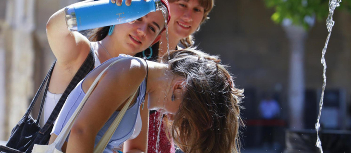 Unas turistas se refrescan en la Fuente de los Naranjos de la mezquita-catedral de Córdoba