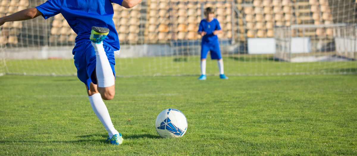 Dos niños juegan al fútbol