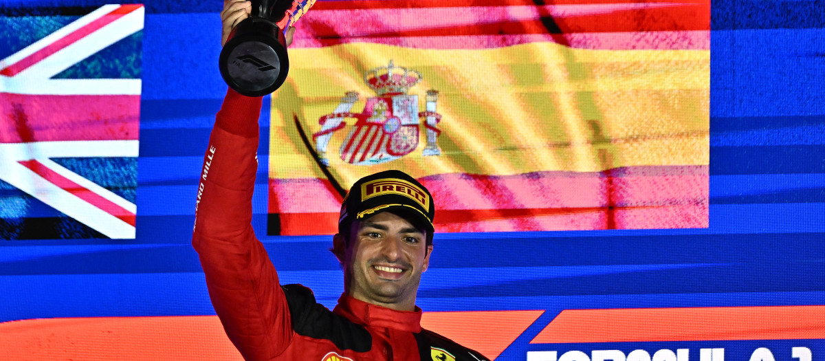 Carlos Sainz celebra la victoria en Singapur con la bandera de España de fondo