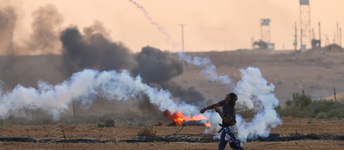 A Palestinian demonstrator returns a tear gas canister during clashes with Israeli soldiers east of Rafah in the southern Gaza Strip near the Israel-Gaza border fence on September 23, 2023. (Photo by SAID KHATIB / AFP)