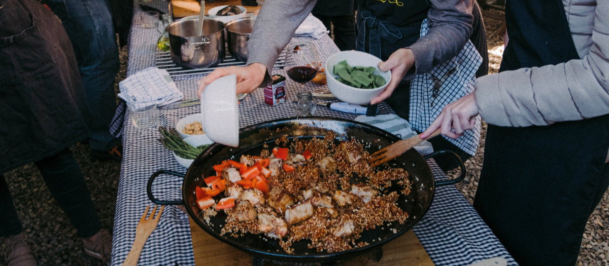 Un grupo de extranjeros prepara una paella