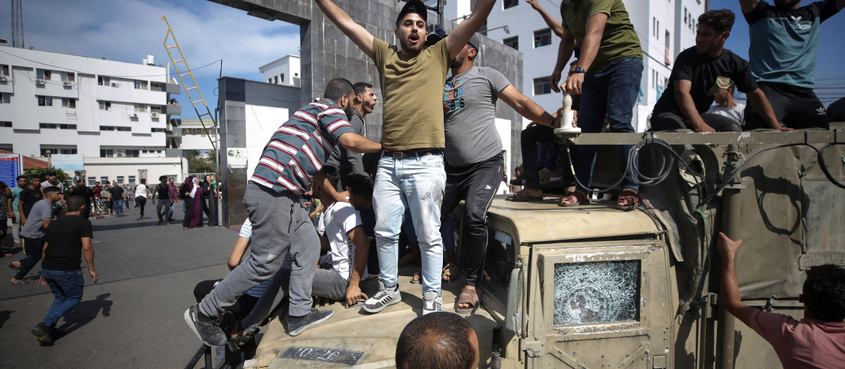 Palestinos sobre un jeep militar israelí por las calles de Gaza.