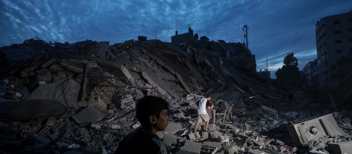 -FOTODELDÍA- EA6592. CIUDAD DE GAZA (---), 07/10/2023.- Menores inspeccionan los alrededores destruidos de la Torre Palestina después de que aviones de combate israelíes la atacaran en la ciudad de Gaza, el 7 de octubre de 2023. A principios de este mismo sábado, se lanzaron andanadas de cohetes desde la Franja de Gaza en un ataque sorpresa contra Israel reivindicado por el movimiento islamista Hamás. En una declaración televisada, el primer ministro israelí dijo que el país está en guerra. EFE/ Mohammed Saber