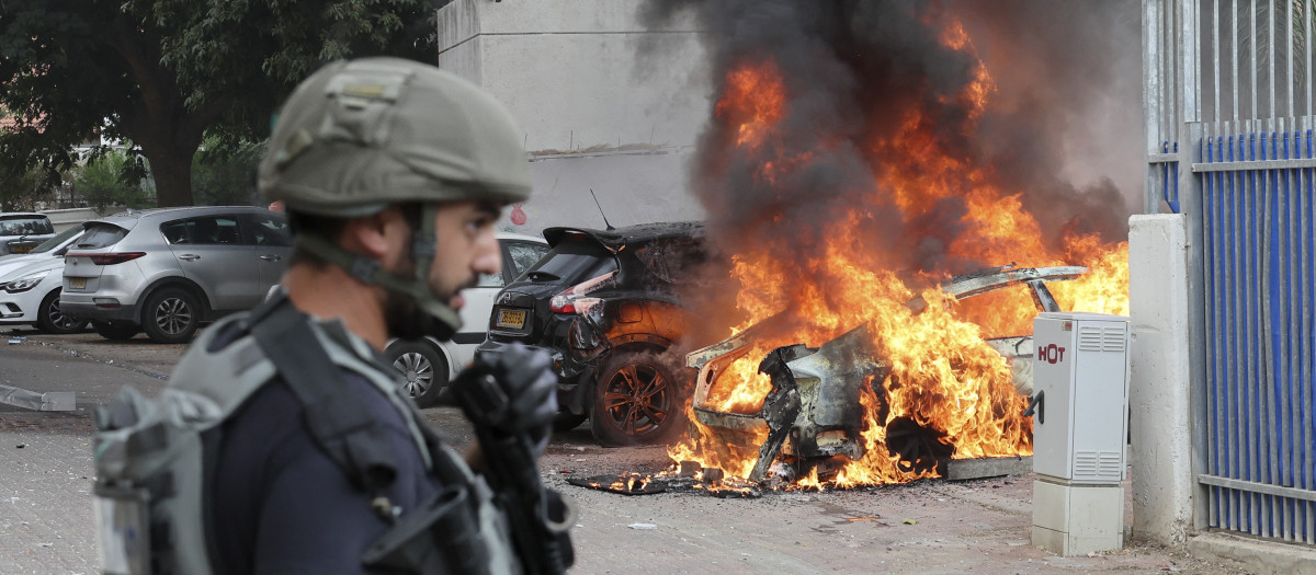 Un miembro soldado israelí, cerca de un coche alcanzado por un cohete disparado desde Gaza