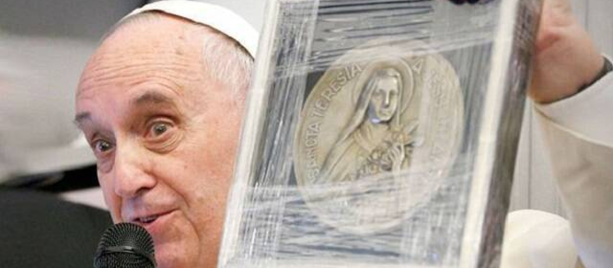 El Papa sostiene un relieve de santa Teresita de Lisieux