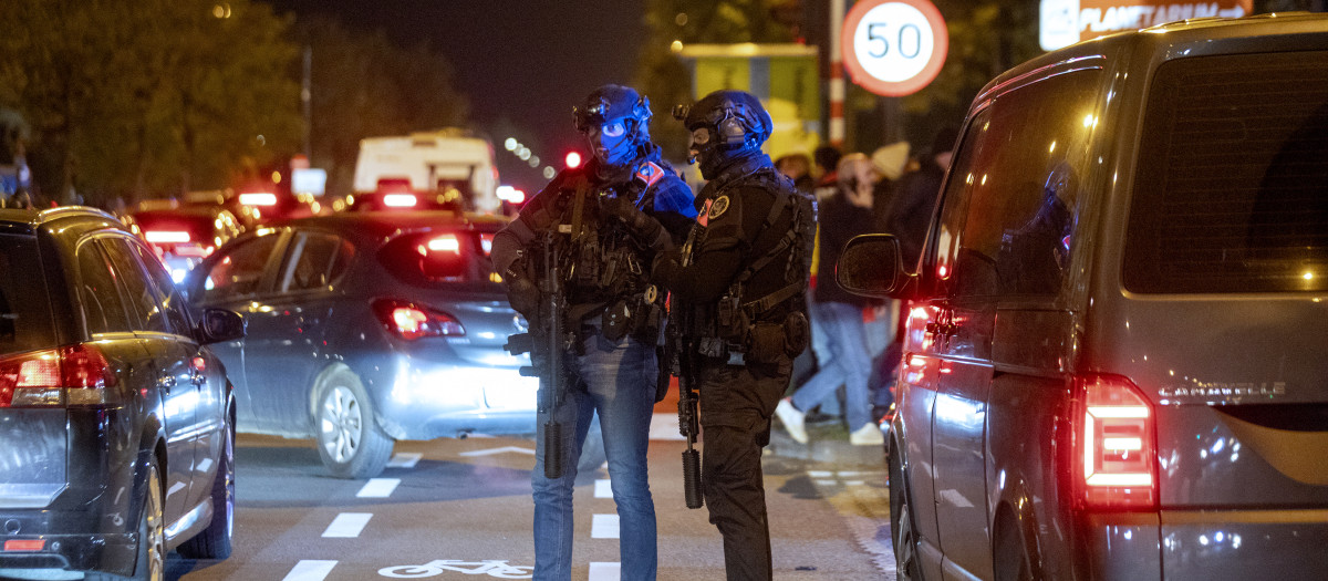 Police officers stand guard as supporters leave the King Baudouin Stadium following the Euro 2024 qualifying football match between Belgium and Sweden in Brussels on October 16, 2023, after two Swedes were shot dead in an attack in Brussels. Belgium's Euro 2024 qualifier against Sweden was abandoned at half-time and fans were kept in the stadium for security reasons after two Swedes were shot dead in an attack in Brussels on October 16, 2023. (Photo by HATIM KAGHAT / Belga / AFP) / Belgium OUT