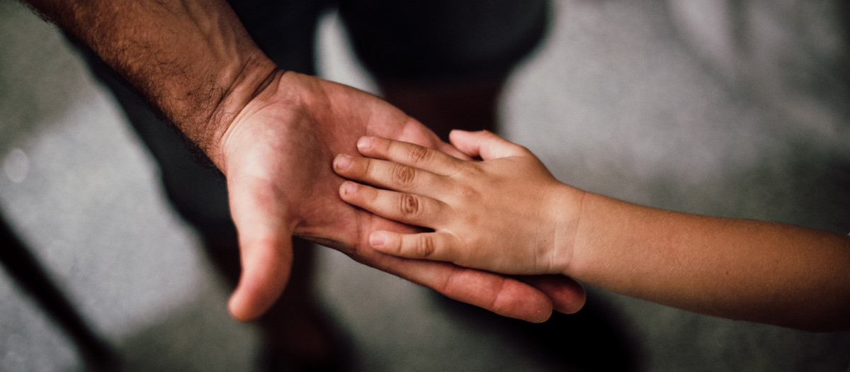 La mano de hijo sobre la de su padre