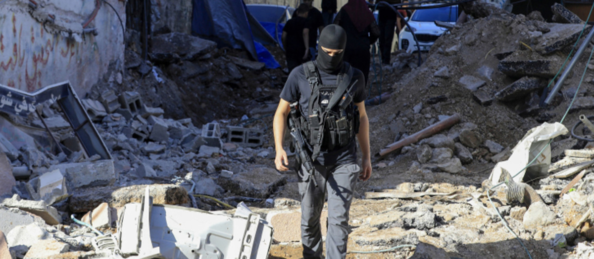 Un palestino armado camina entre los escombros tras la redada de tropas israelíes en el campo de refugiados de Nur Shams