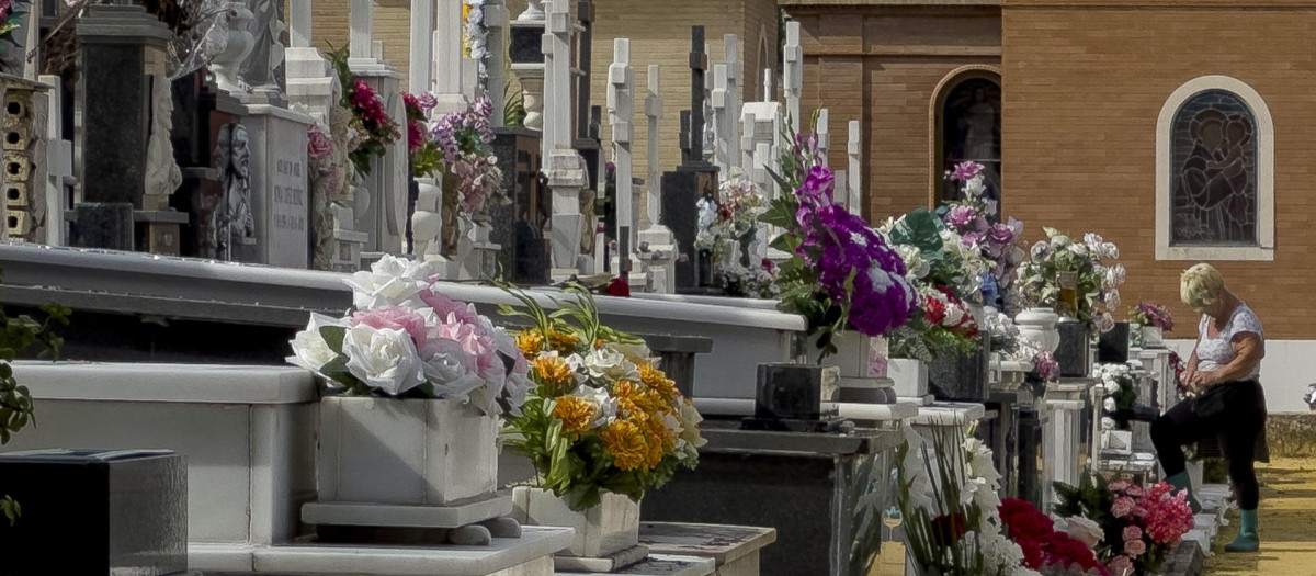 Personas limpian y colocan flores como preparativo del Día de Todos los Santos