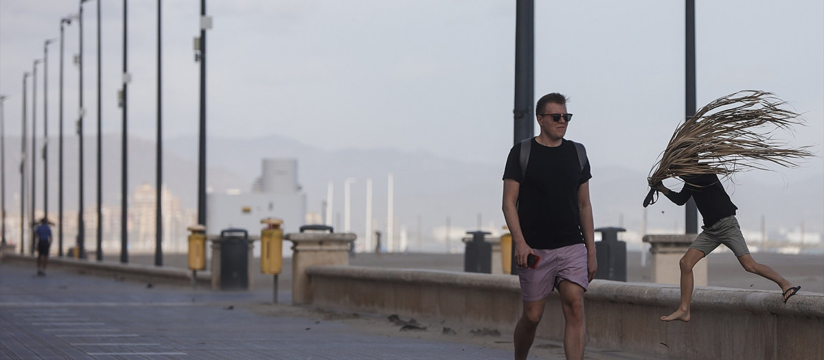 Un hombre anda por el paseo de la playa de la Malvarrosa con fuertes rachas de viento durante la borrasca Ciarán