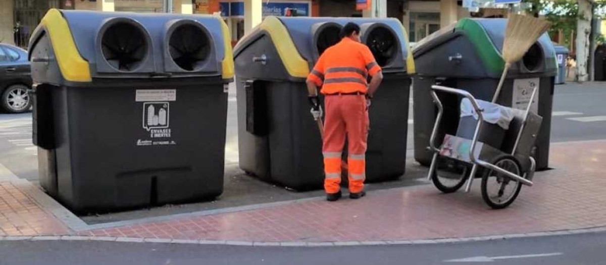 Un trabajador de Sadeco junto a unos contenedores