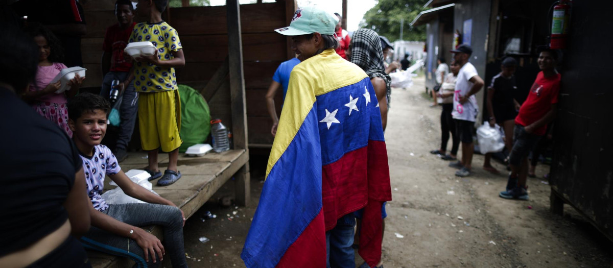 William Maldonado, un migrante venezolano de 22 años sostiene una bandera de Venezuela