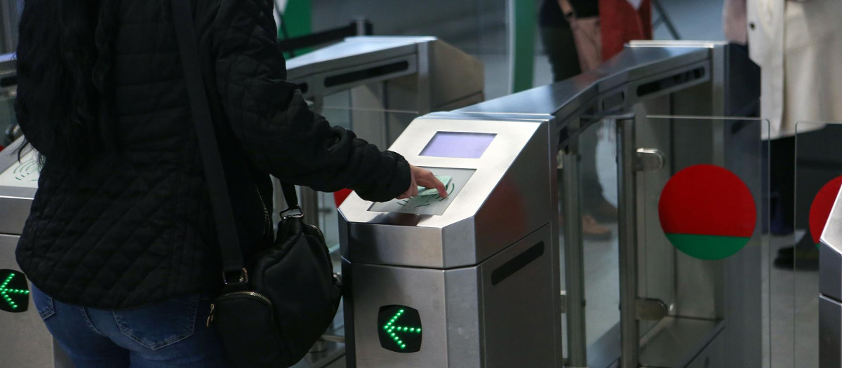 Una usuaria pasa su tarjeta de viaje por un torno de acceso al metro de Granada