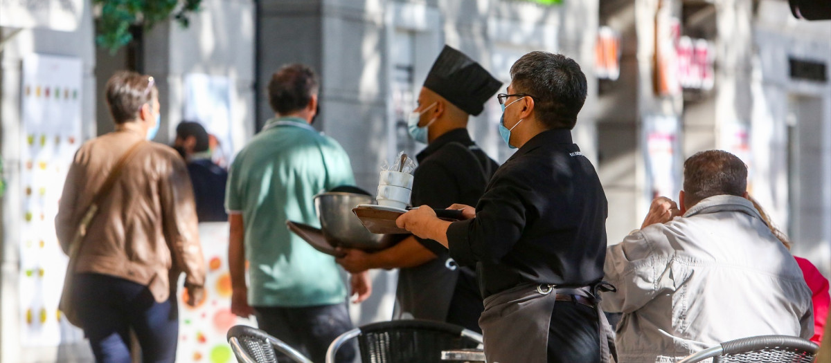 Dos camareros trabajan en una de las terrazas ubicadas en el Paseo del Prado