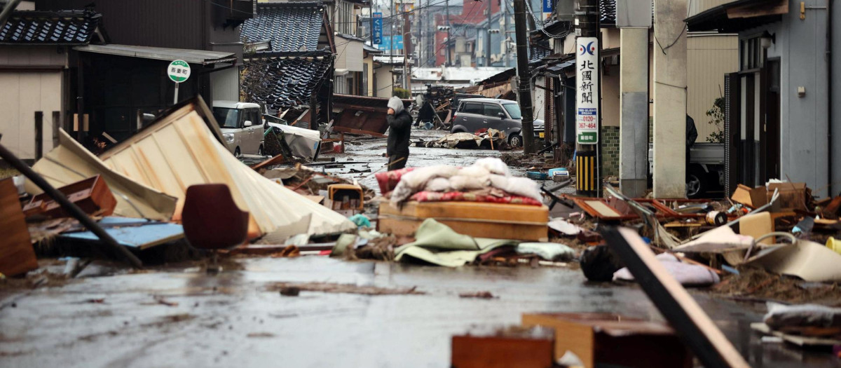 Un hombre en una calle cubierta de escombros tras el terremoto en Suzu, prefectura de Ishikawa