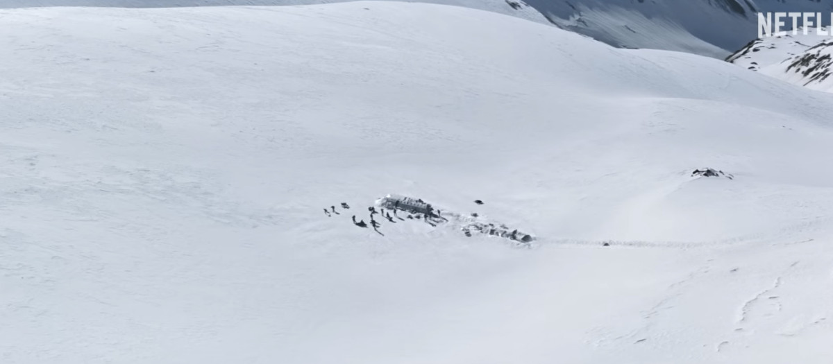 Un plano de 'La sociedad de la nieve', en el que se aprecia a lo lejos el avión siniestrado