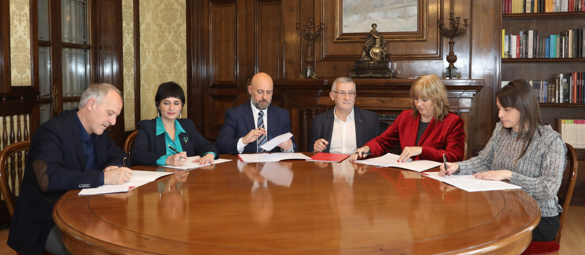 Miembros del Gobierno de Navarra firman el acuerdo con los dos representantes de Bildu, a la izquierda