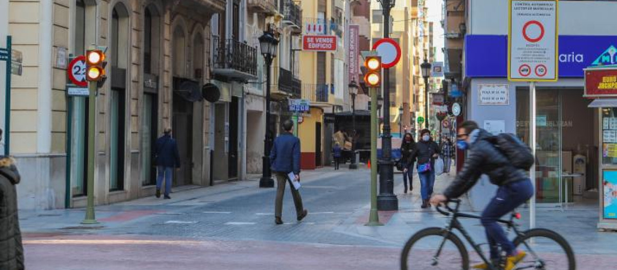 Un ciclista pasa junto a una señal que restringe el tráfico rodado en Castellón