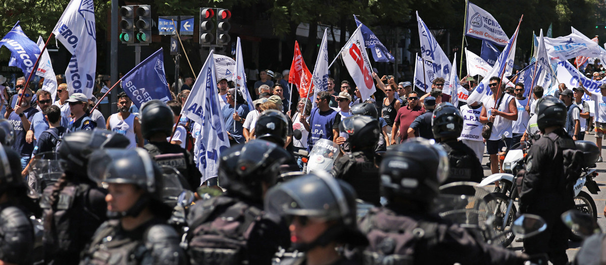 Un grupo de manifestantes argentinos vigilados por la policía antidisturbios en Córdoba, Argentina.