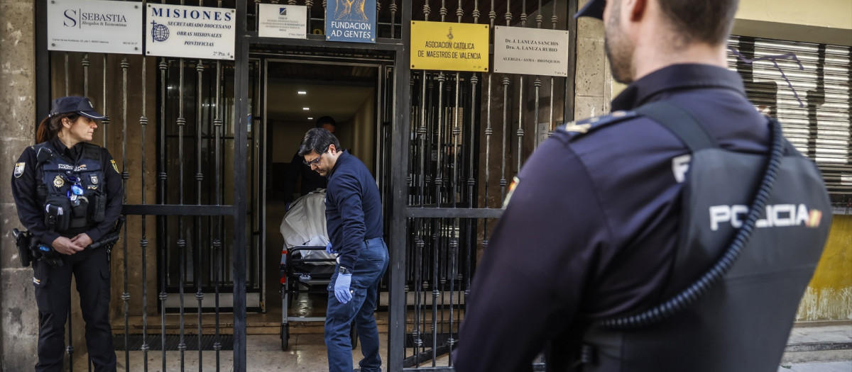 Momento en el que la Policía Nacional levanta el cuerpo del canónigo de su domicilio, en Valencia