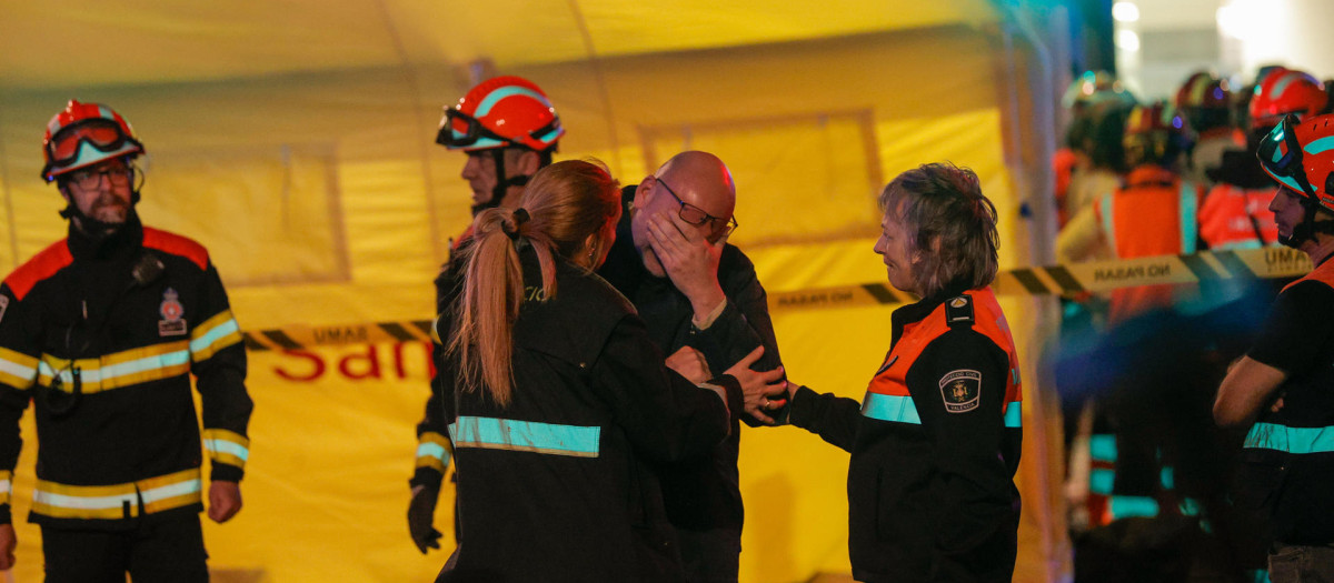 Imagen de los bomberos junto a uno de los vecinos afectados