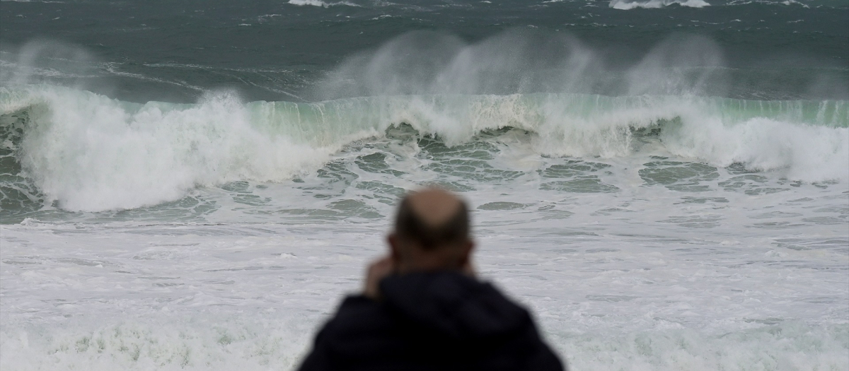Un hombre observa las olas durante el frente meteorológico