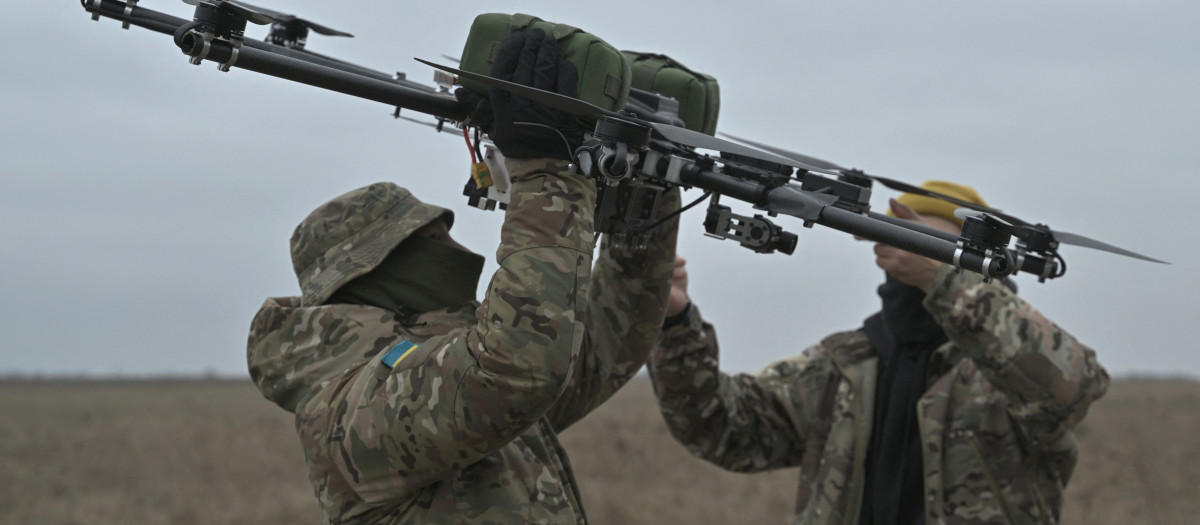 Pilotos llevan un dron en un campo de entrenamiento en la región de Kiev