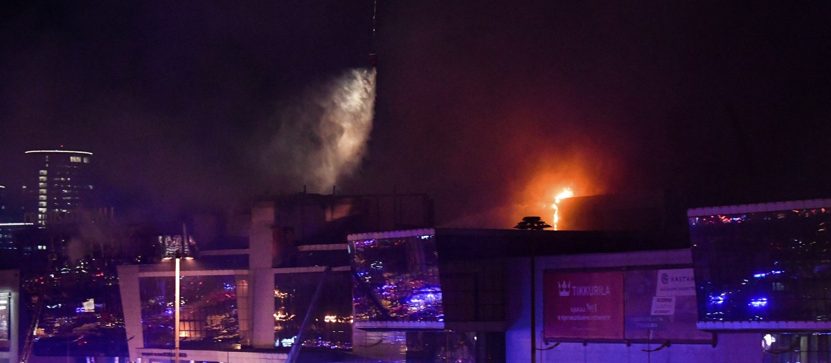 Un helicóptero de extinción de incendios arroja agua sobre la sala de conciertos Crocus City Hall en llamas tras el tiroteo en Krasnogorsk, en las afueras de Moscú