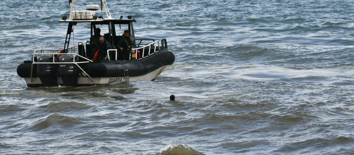 Una lancha de la Guardia Civil acude a rescatar a un migrante marroquí que nada frente a la playa del Tarajal, en Ceuta, en 2021