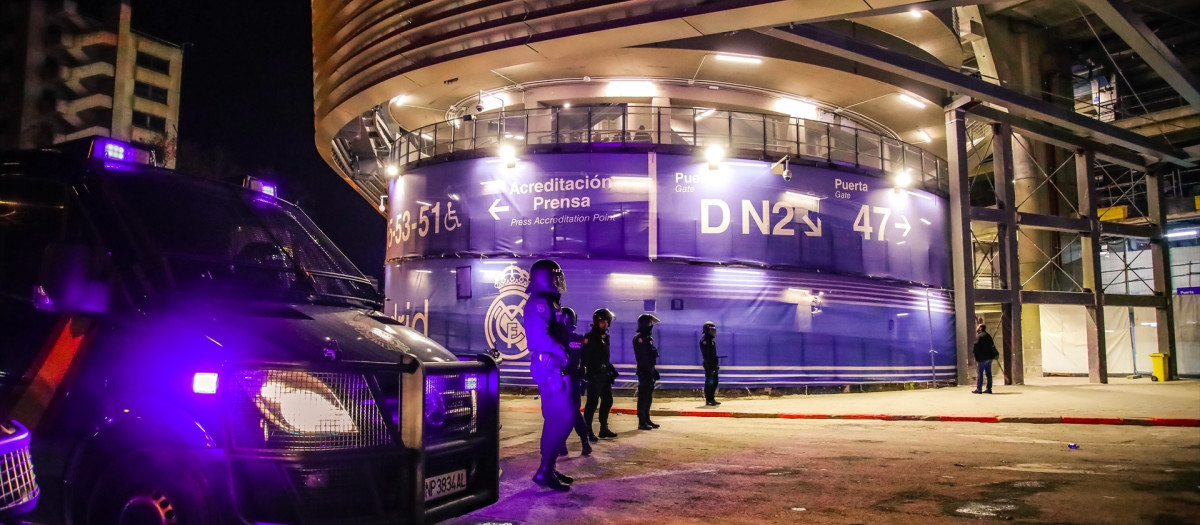 Agentes de policía escoltan a los aficionados en las inmediaciones del estadio Santiago Bernabéu