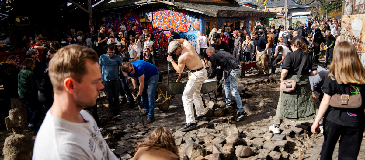 Los residentes del barrio de Christiania desentierran conjuntamente los adoquines de Pusher Street, en Copenhague, Dinamarca