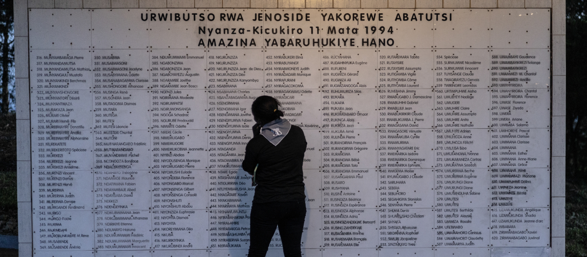 Una mujer frente al listado de los asesinados en el genocidio de 1994 en Ruanda