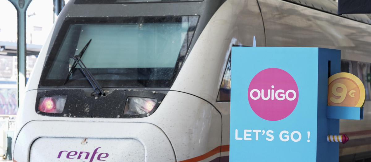 Un tren de Renfe pasa junto a un cartel publicitario de Ouigo, esta mañana en Valladolid