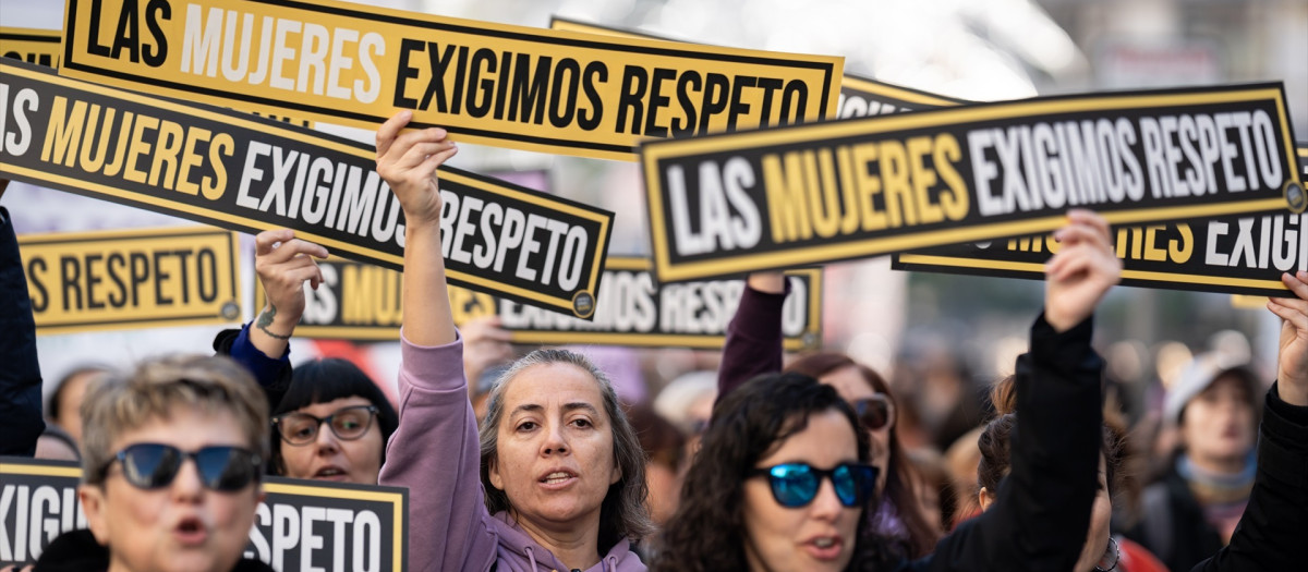 Varias personas sujetan carteles durante una manifestación por el 25N