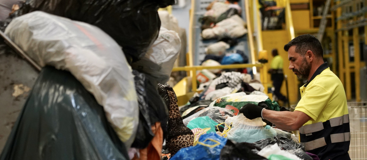 Un trabajador en la línea de clasificación textil de la planta Koopera de Valencia