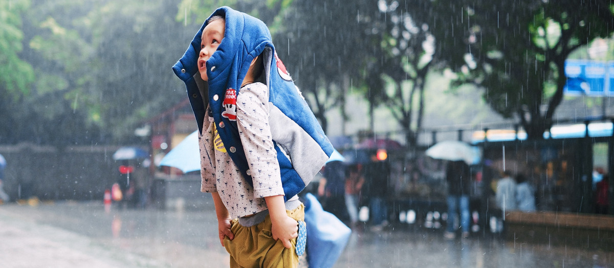 Niño protegiéndose de la lluvia