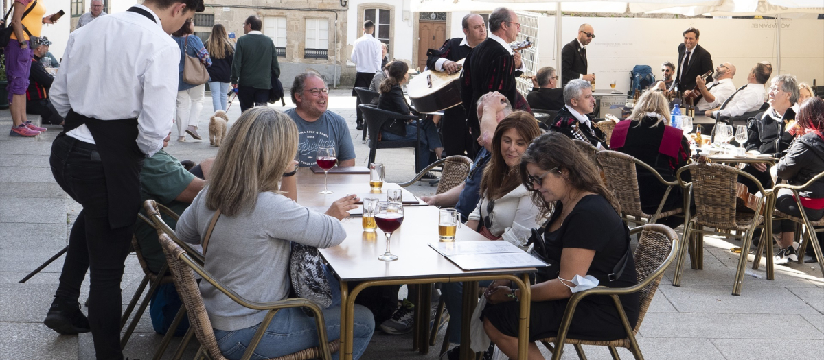 Un grupo de turistas consulta una carta en la terraza de un bar en Santiago de Compostela