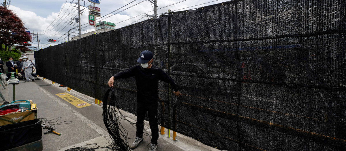 Un trabajador termina el trabajo de instalación de la barrera para bloquear la vista del Monte Fuji de Japón