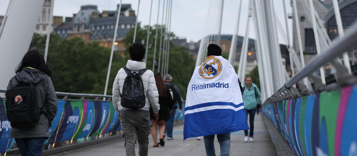 Un aficionado del Real Madrid porta su bandera por las calles de Londres