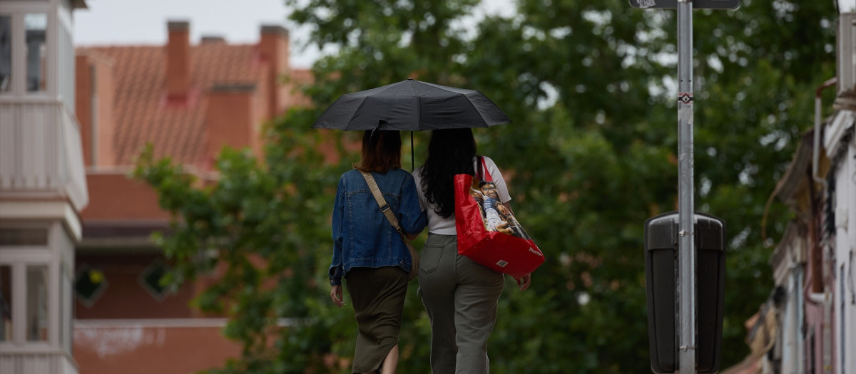 Dos mujeres se protegen de la lluvia con un paraguas