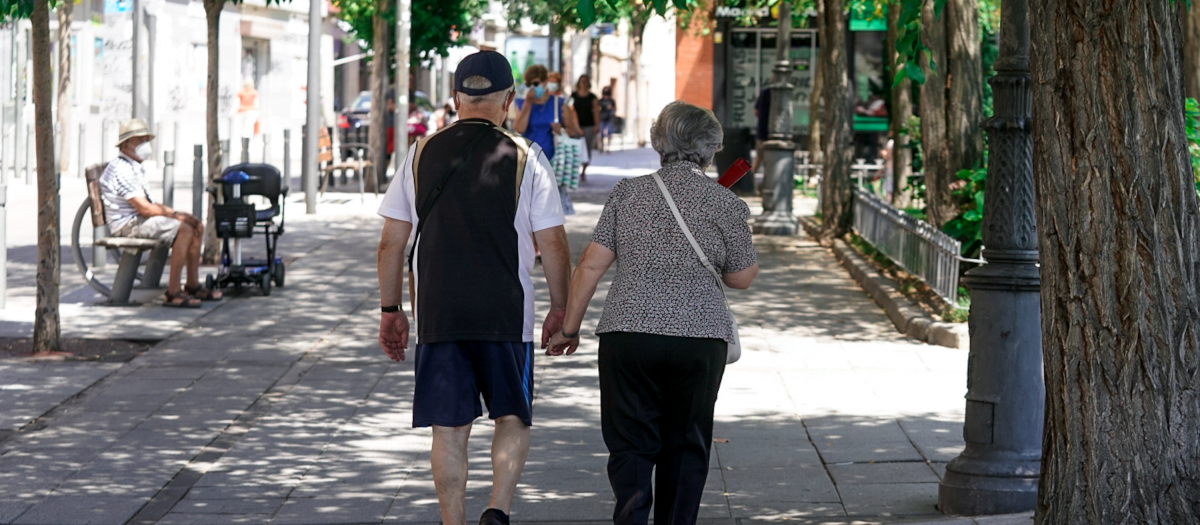 Una pareja camina de la mano por Madrid