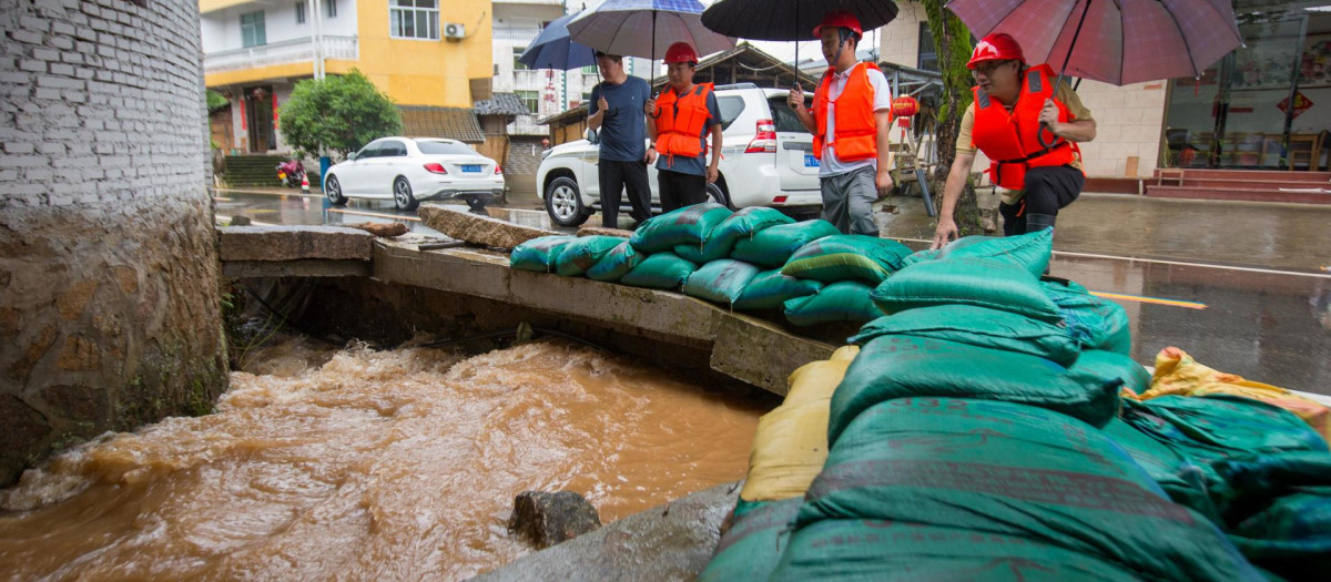 Los equipos de rescate inspeccionan la inundación en un canal de drenaje en la aldea de Hongxing del municipio de Xingcun de Wuyishan