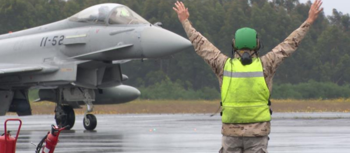 Un militar realiza señales a un avión.