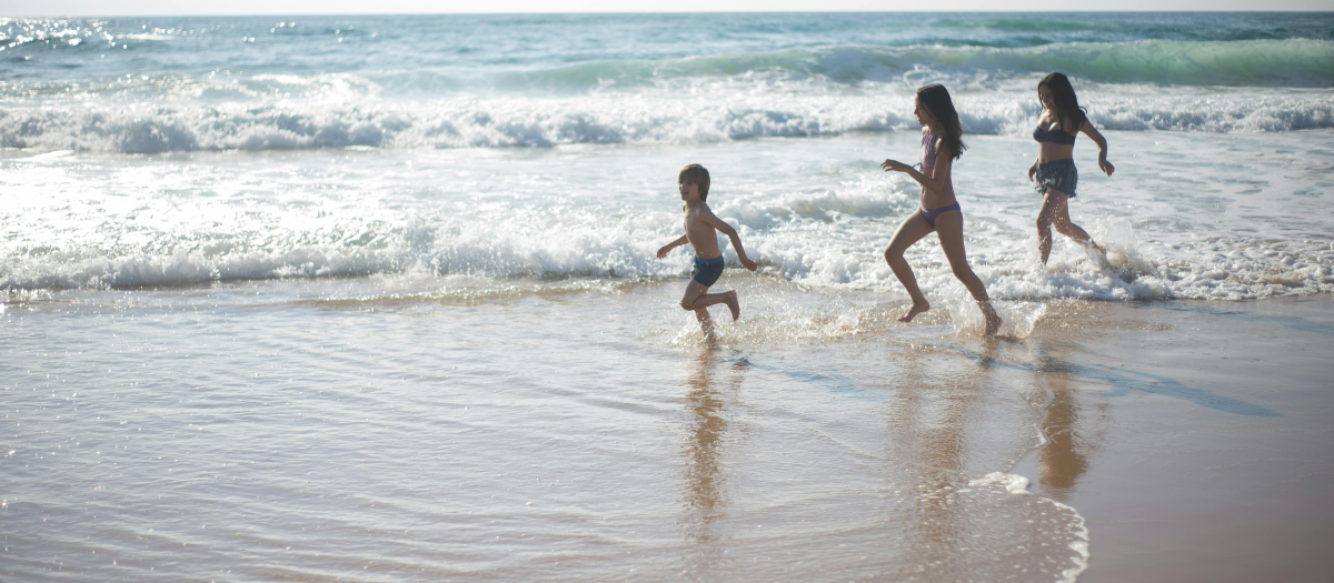 Tres niños juegan en la playa