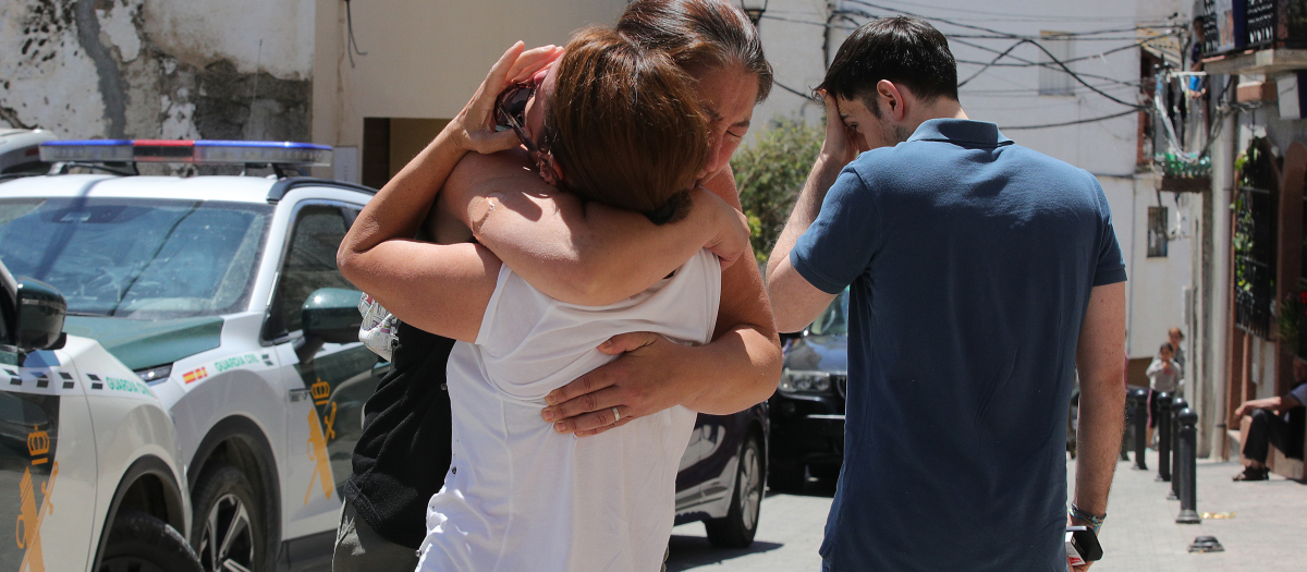 Vecinos de Zafarraya (Granada) se abrazan cerca del lugar dónde presuntamente un hombre de 34 años ha matado este sábado a su expareja, una joven de 20 años con la había mantenido una relación hasta hace escaso tiempo, y a la madre de ella, de 49, y después se ha suicidado