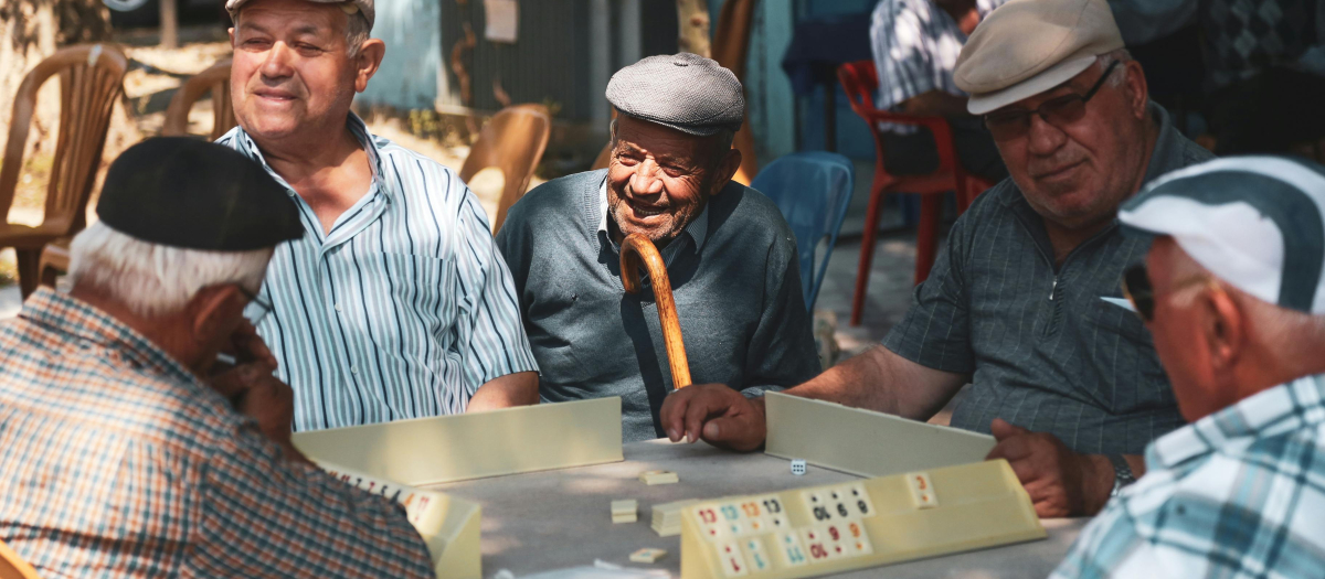 Personas mayores jugando en la calle a un juego de mesa
